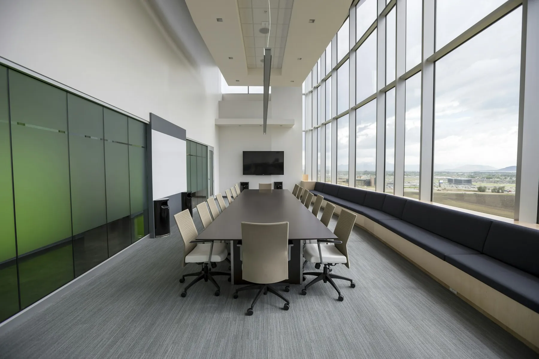 A long conference table beside floor-to-ceiling windows
